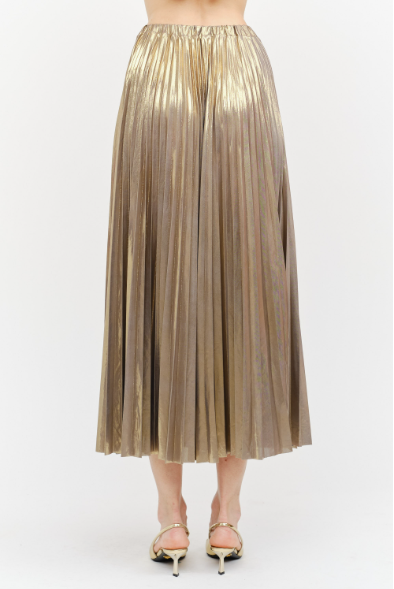 A metallic gold pleated midi skirt worn by a model, paired with gold high-heeled sandals, shown from the waist down against a plain white background.